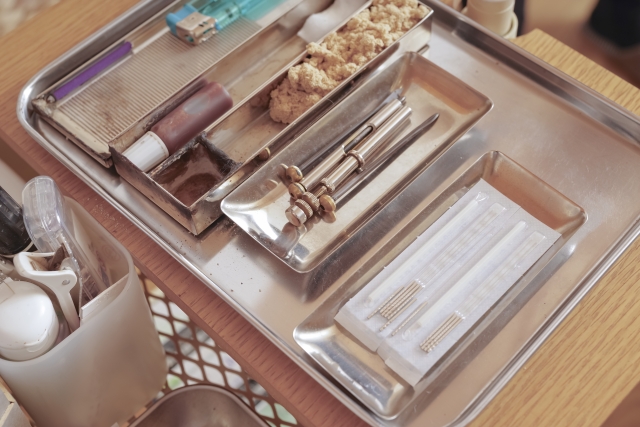 Organized makeup and beauty organizer trays containing cosmetics, brushes, and accessories on wooden surface